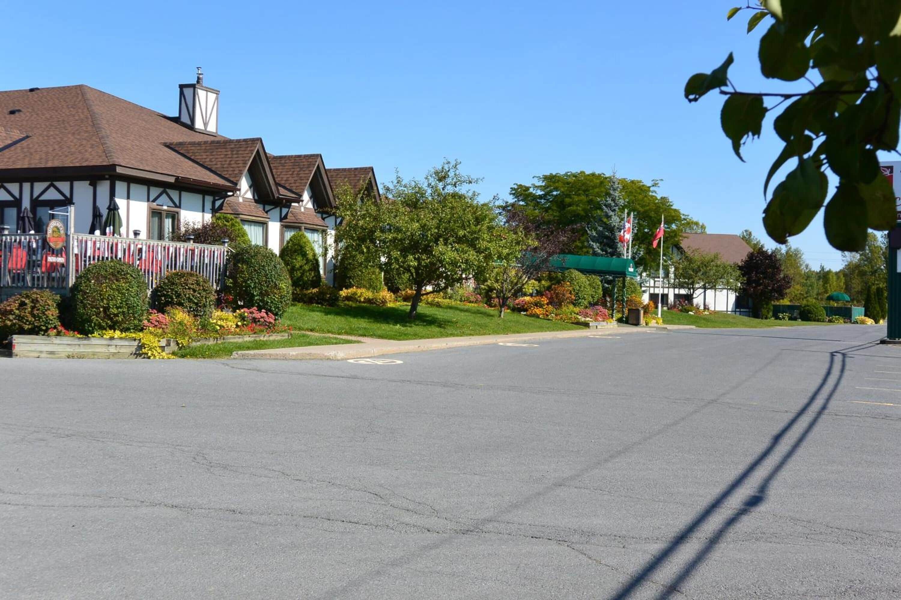 A quiet street with traditional houses, a clear sky, and well-maintained lawns.