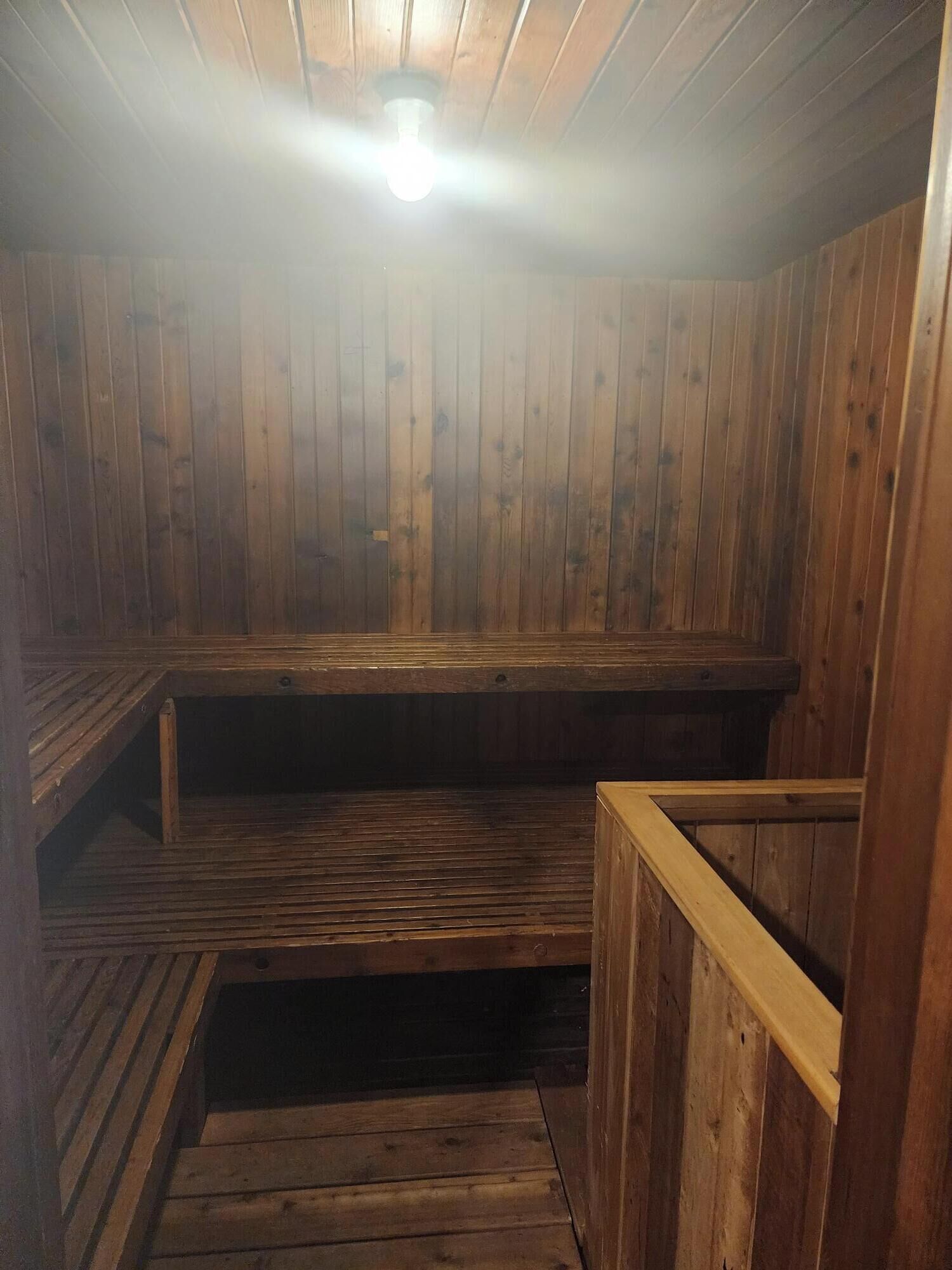 Una sauna con bancos de madera y suelo inclinado.