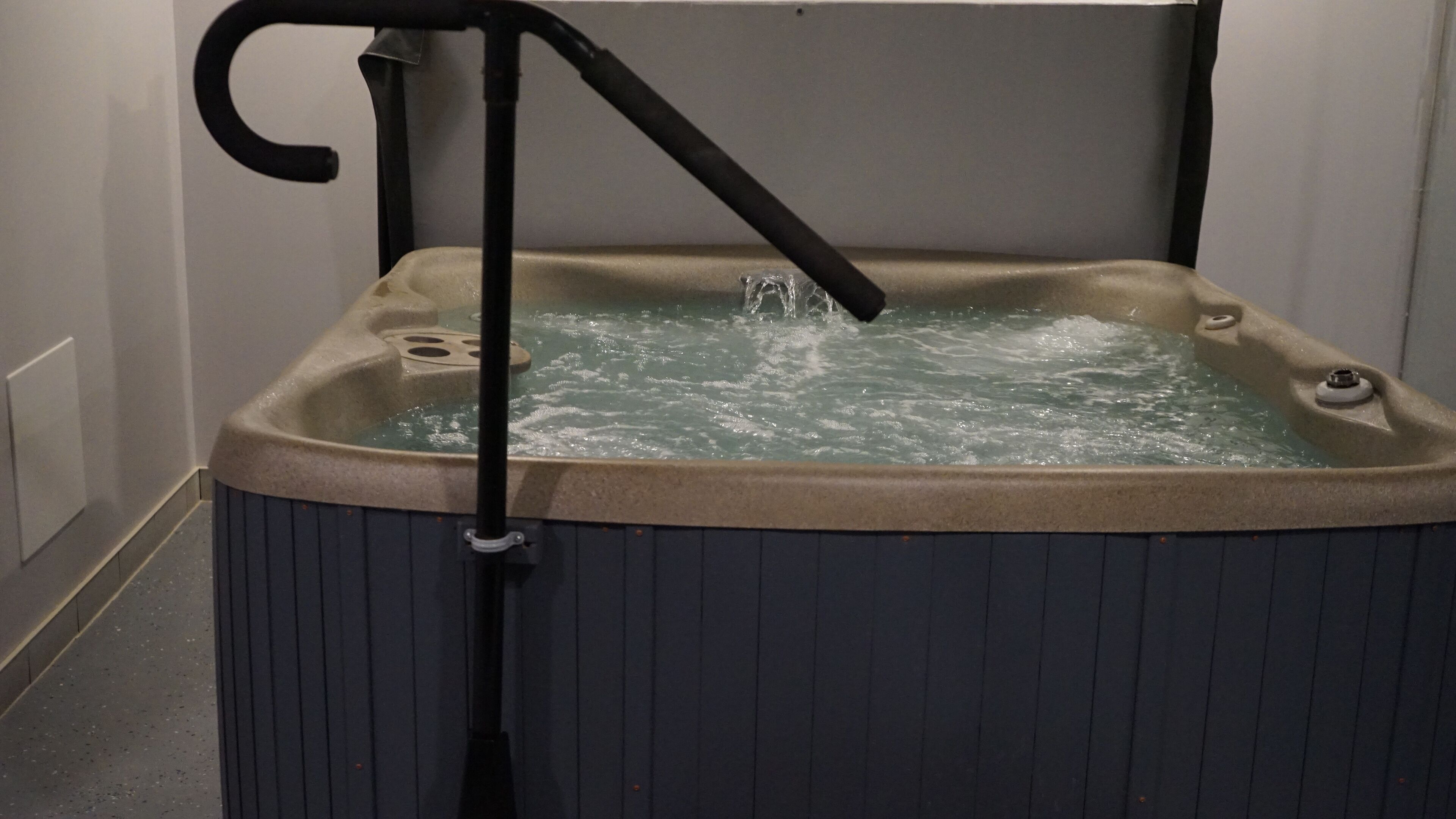 A hot tub with a pump and a control handle.