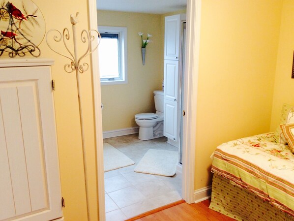 A bathroom with a toilet, a window, and a white door.