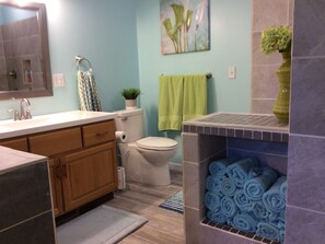 A bathroom with a sink, toilet, and a towel rack.