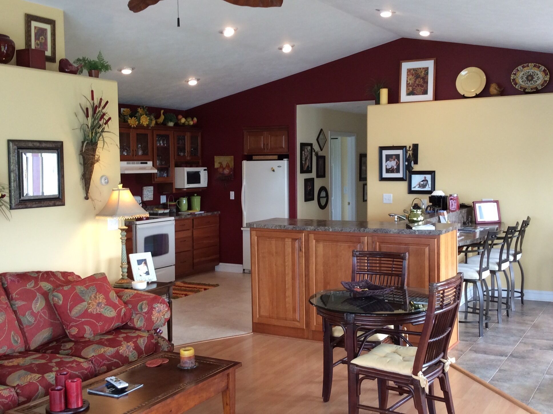 A spacious living room with a sofa, a coffee table, and a dining area with chairs and a glass-top table.