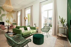 Habitación Royal, varias camas | Área de sala de estar | Televisión de pantalla plana de 32 pulgadas con canales por cable