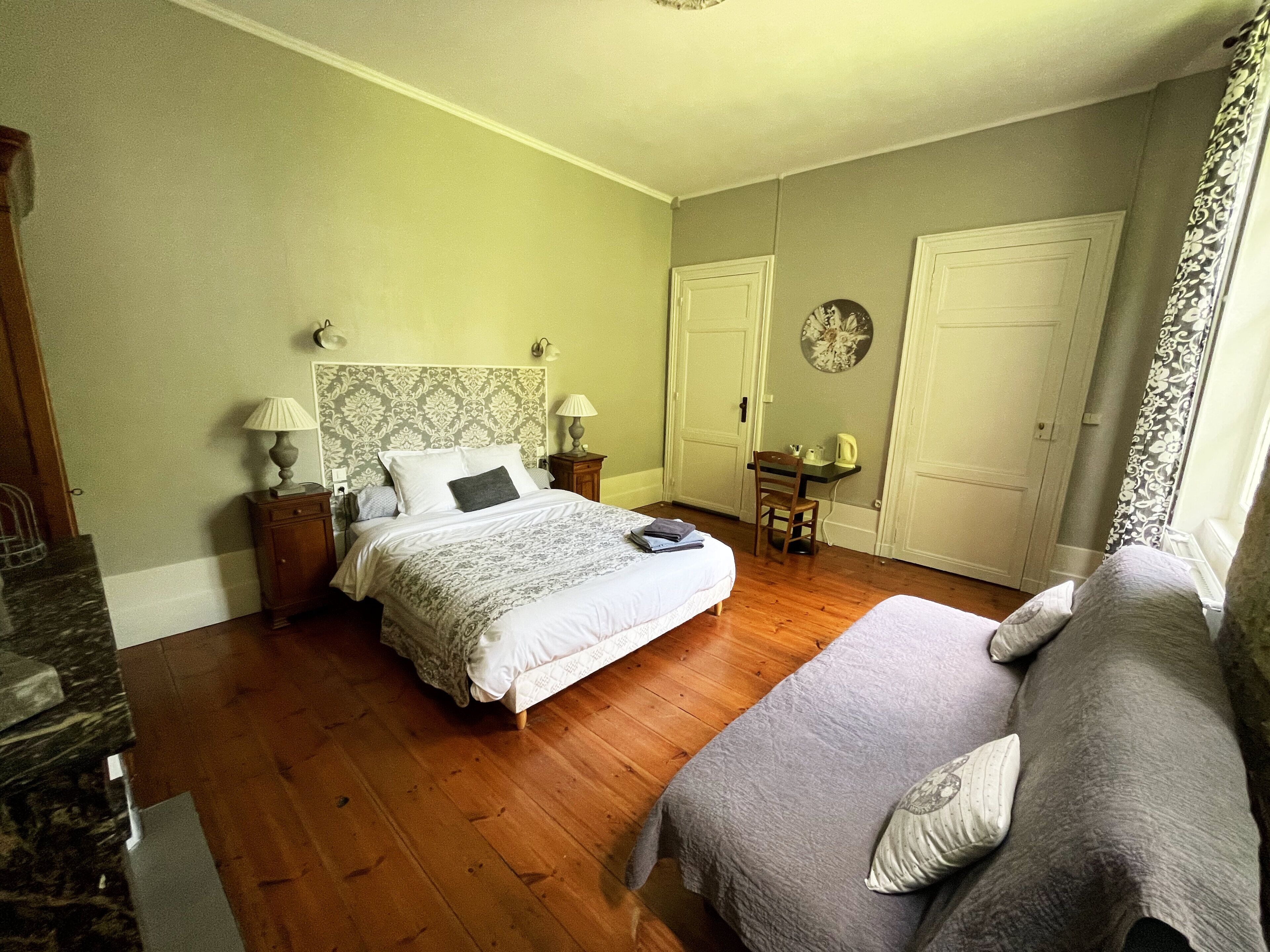 Un dormitorio con cama, una silla, un escritorio y un armario.