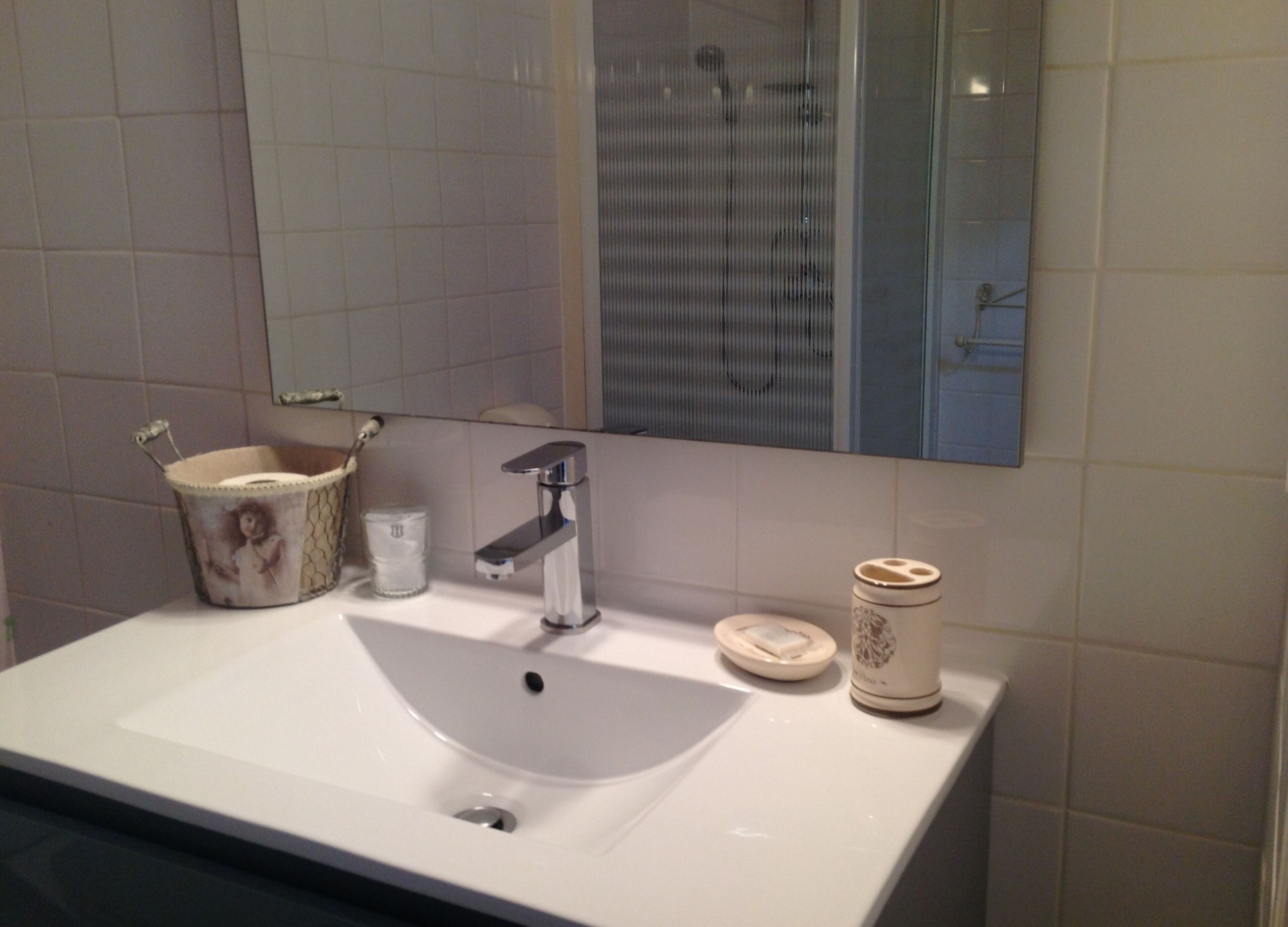 A bathroom with a white sink, a mirror, and a toilet.