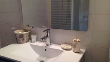 A bathroom with a white sink, a mirror, and a toilet.
