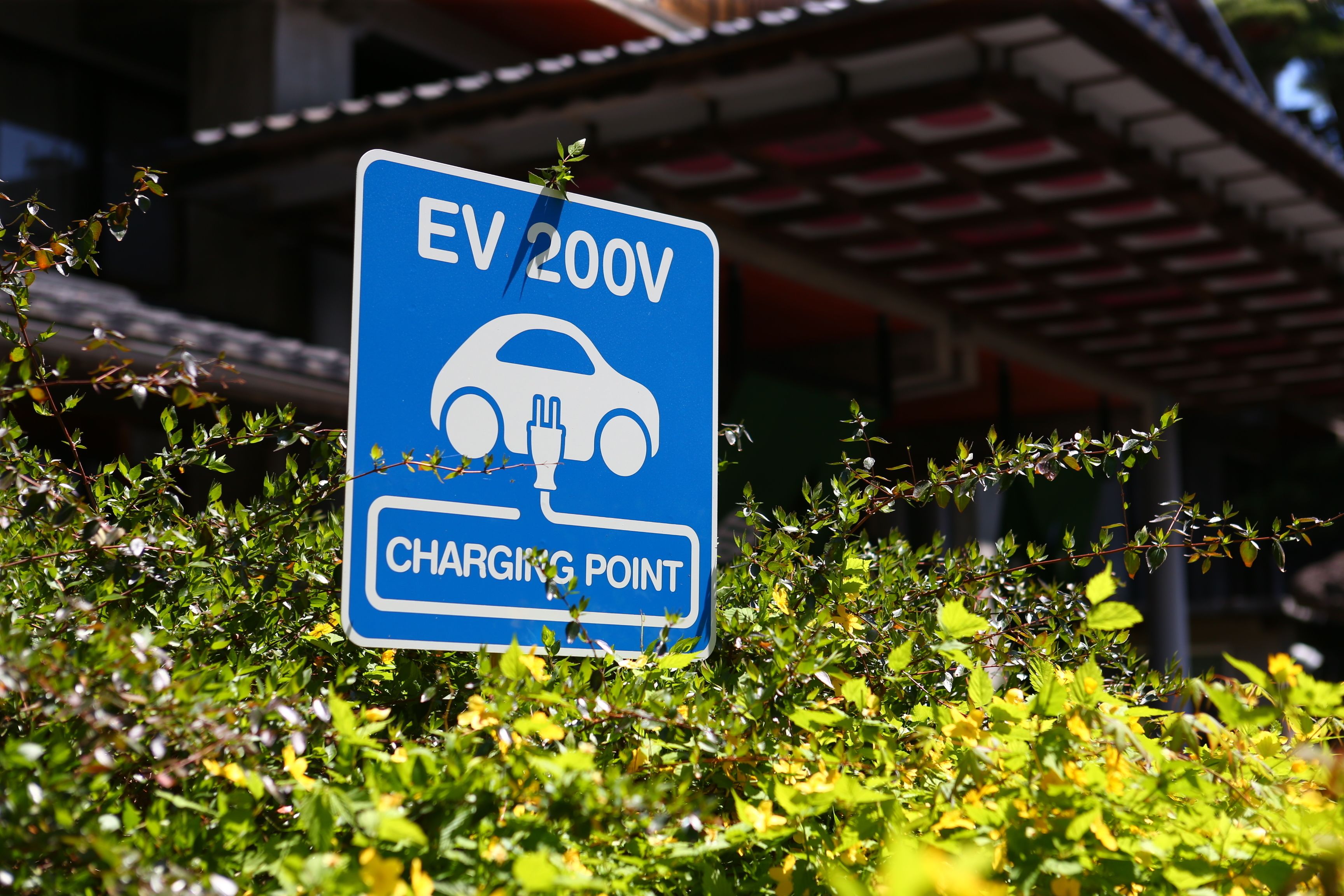 A sign indicating an EV 200V charging point.