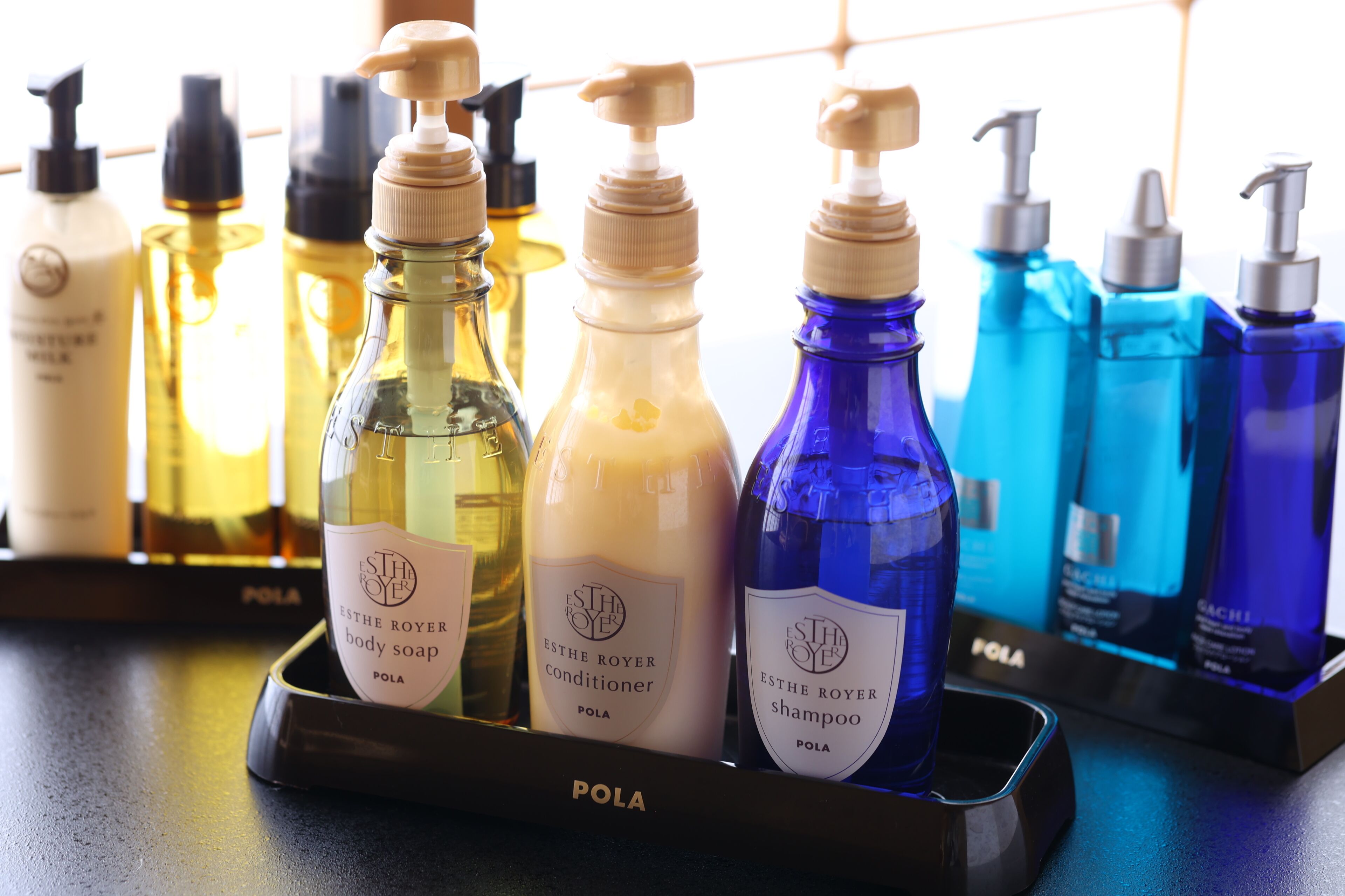 A display of Estee Royer body soap, conditioner, and shampoo in a black tray.