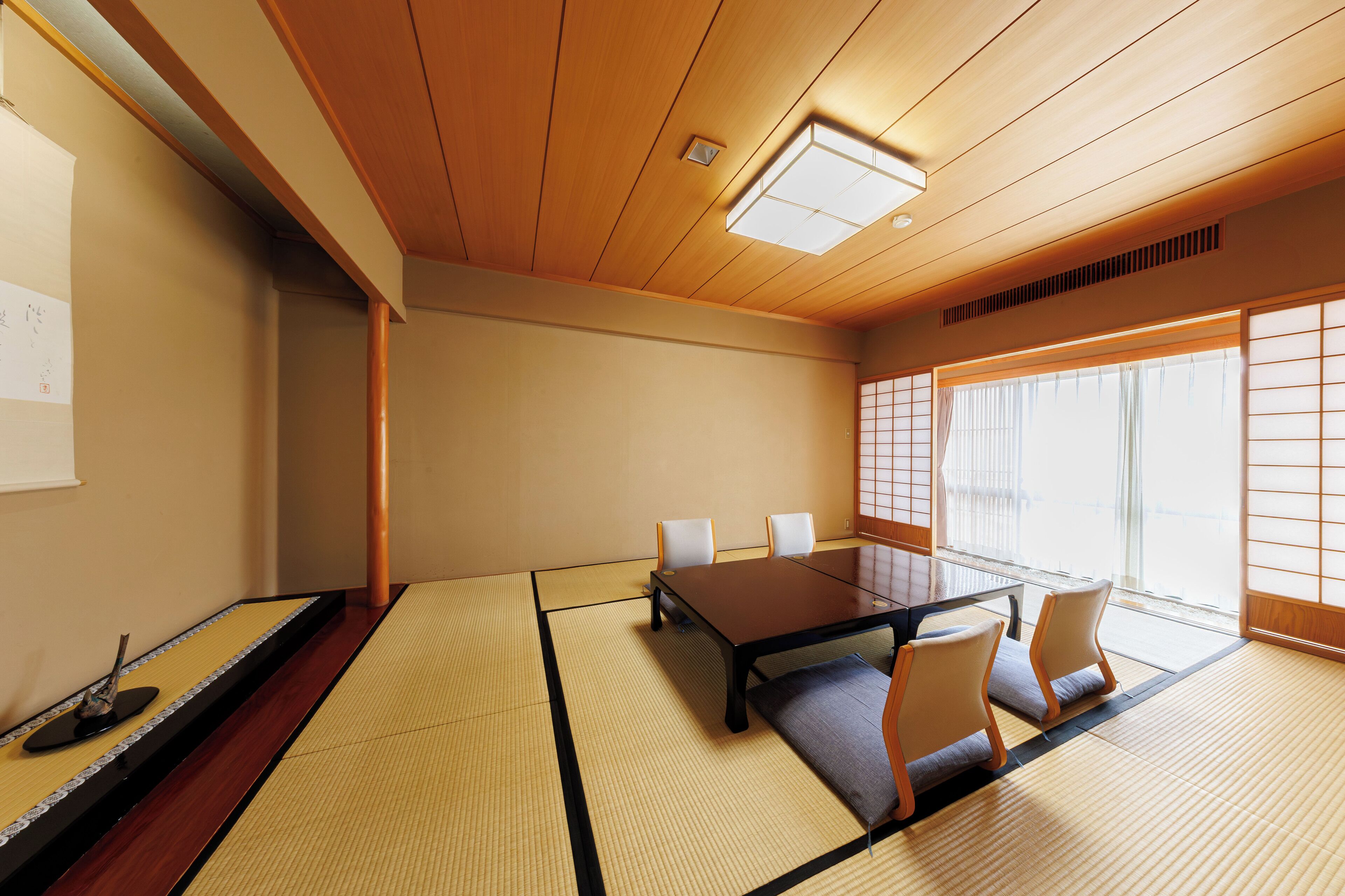 Une pièce de style japonais traditionnel, avec un sol recouvert de tatamis, une table basse et des paravents en papier de riz (shoji).