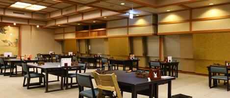 A spacious conference room with multiple tables and chairs, equipped with nameplates and informational materials.