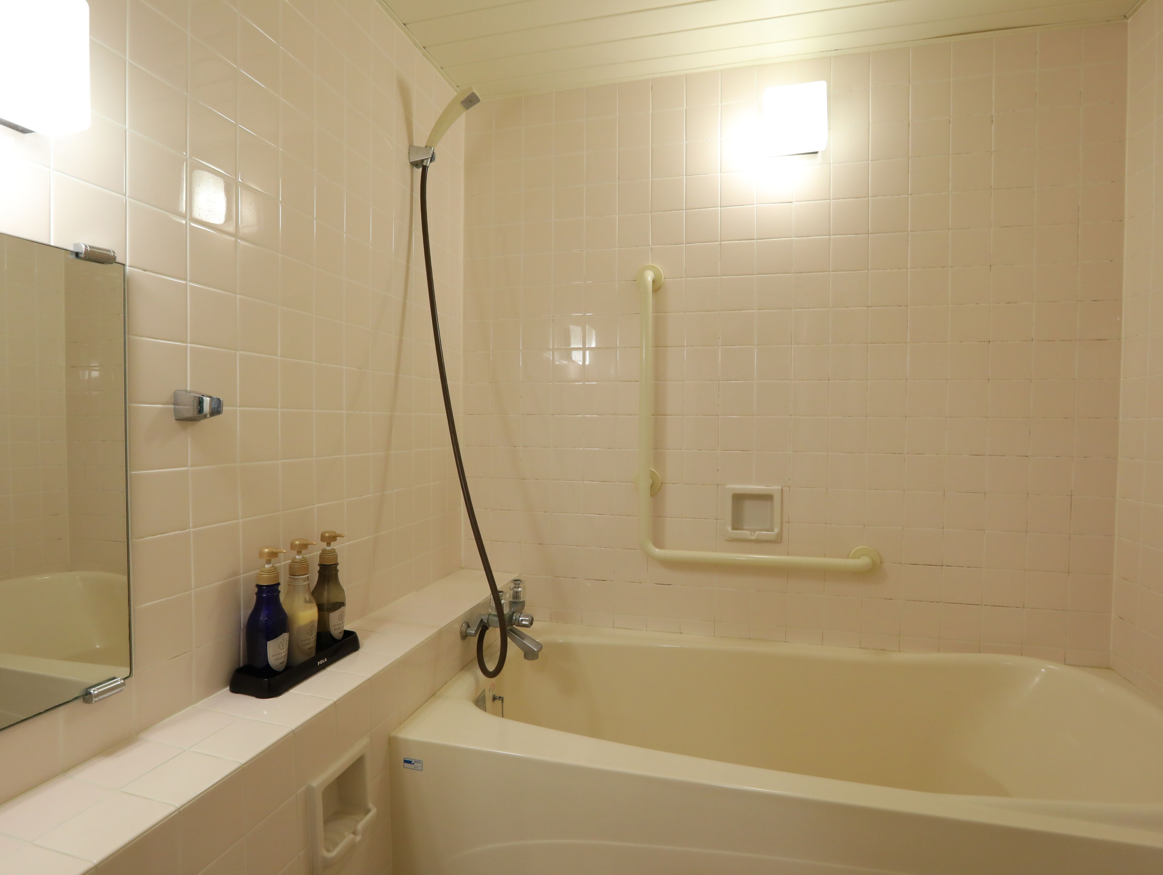 Un baño con bañera, ducha y espejo.
