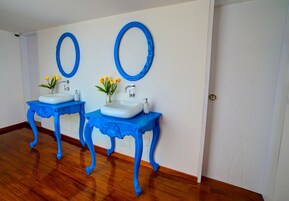 A bathroom with two sinks, each with a blue vanity and matching mirror.
