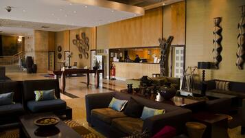 A spacious lobby with a reception desk, seating area, and decorative wall art.