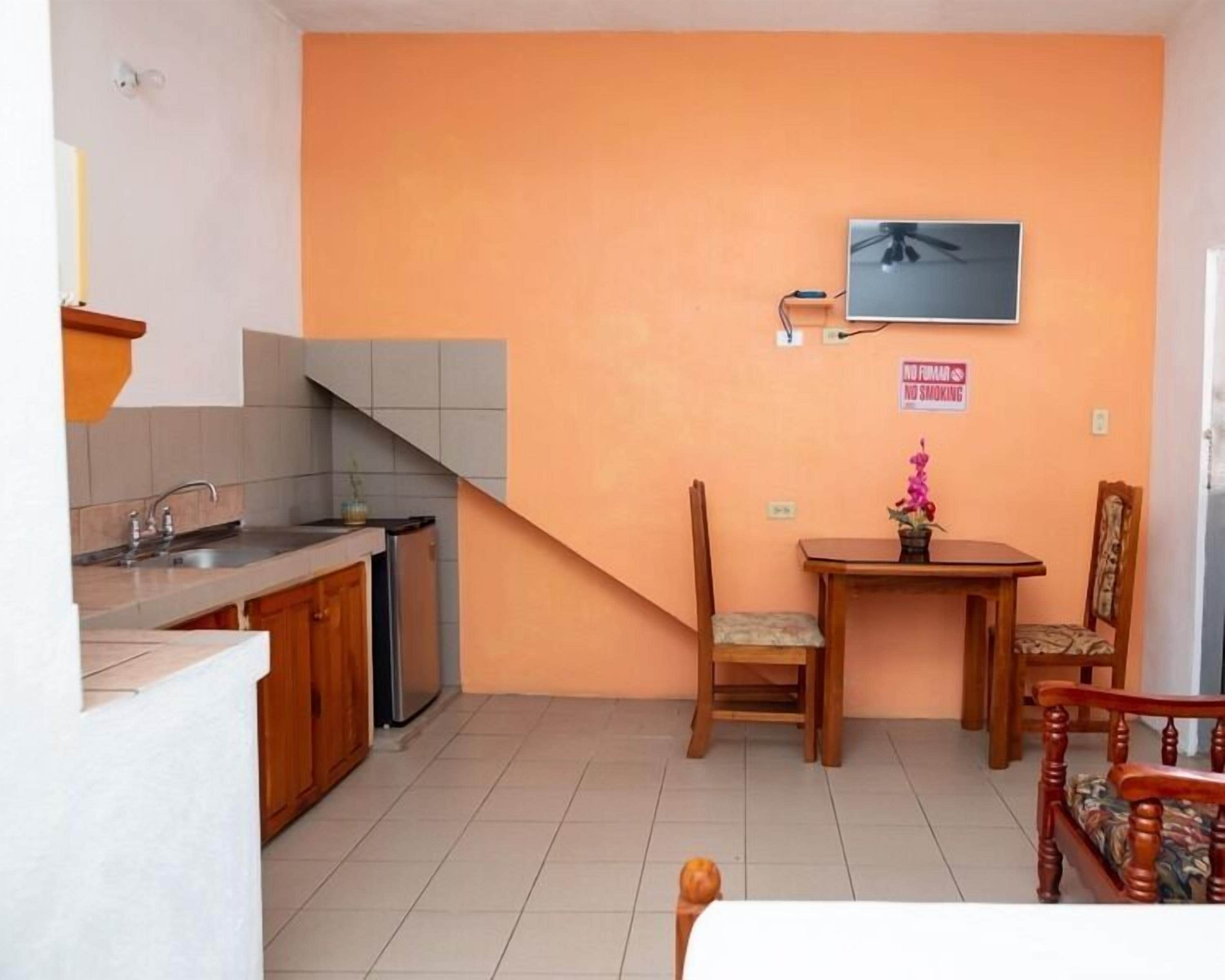 Una cocina compacta con comedor, ventilador de techo y un cartel de 'No Smoking'.