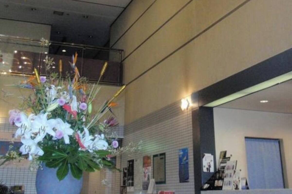 Un intérieur moderne agrémenté d’un luminaire décoratif au plafond et d’un arrangement floral.
