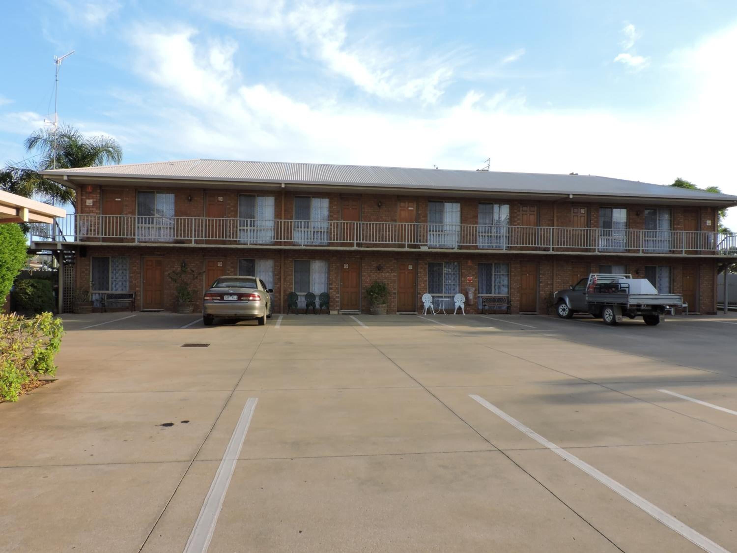 A two-story motel with a parking lot.
