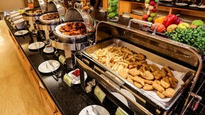 A buffet with various food items including meats, French fries, and a selection of fruits and vegetables. - Formosa Garden Hotel (Tainan)