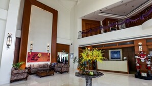 A spacious lobby with a reception desk, sofas, and a decorative table with flowers. - Formosa Garden Hotel (Tainan)