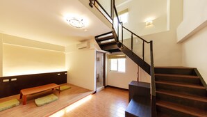 A modern interior with a wooden staircase, a bench, and a bench with a green cushion. - Kenting Green Yard B&B (Hengchun)