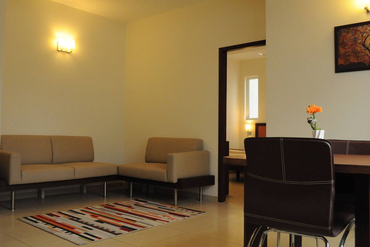 Una sala de estar moderna con un sofá, una mesa de comedor y una silla.