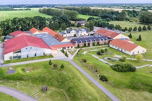 A large building complex with multiple red-roofed structures, surrounded by green fields and trees. - Sport- & Vital-Resort Neuer Hennings Hof (Perleberg)