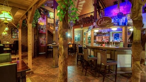 A cozy bar area with wooden furniture, a bar counter, and a sign reading "Cuban Caribbean feeling".