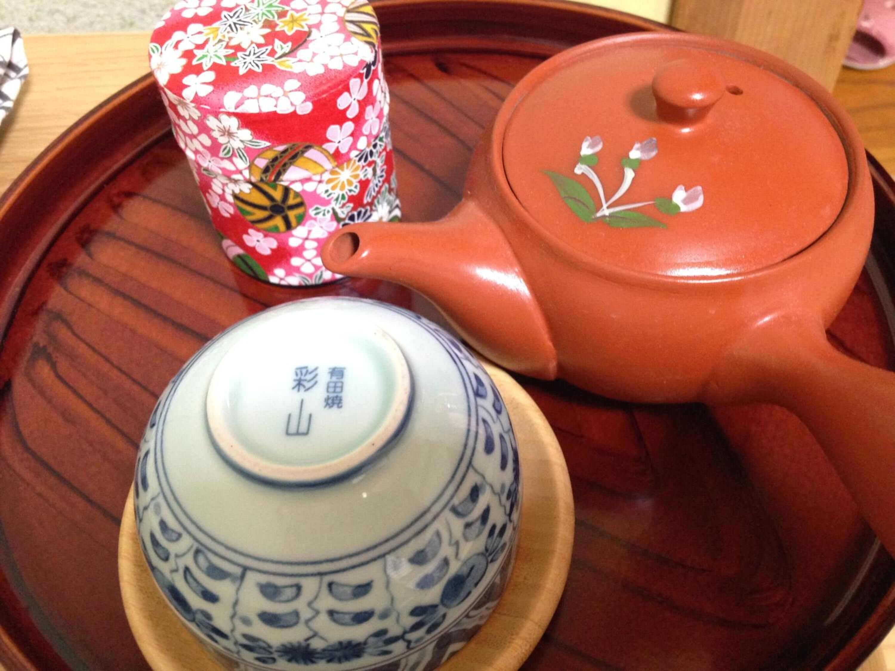 Un juego de té japonés tradicional con tetera y dos tazas sobre una bandeja de madera.