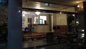 Un restaurant doté d’une paroi en verre, d’un comptoir et d’un espace où sont disposées des chaises et une table.