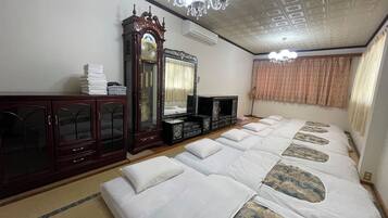Una habitación con una cama grande, un armario de madera, un espejo y una araña.