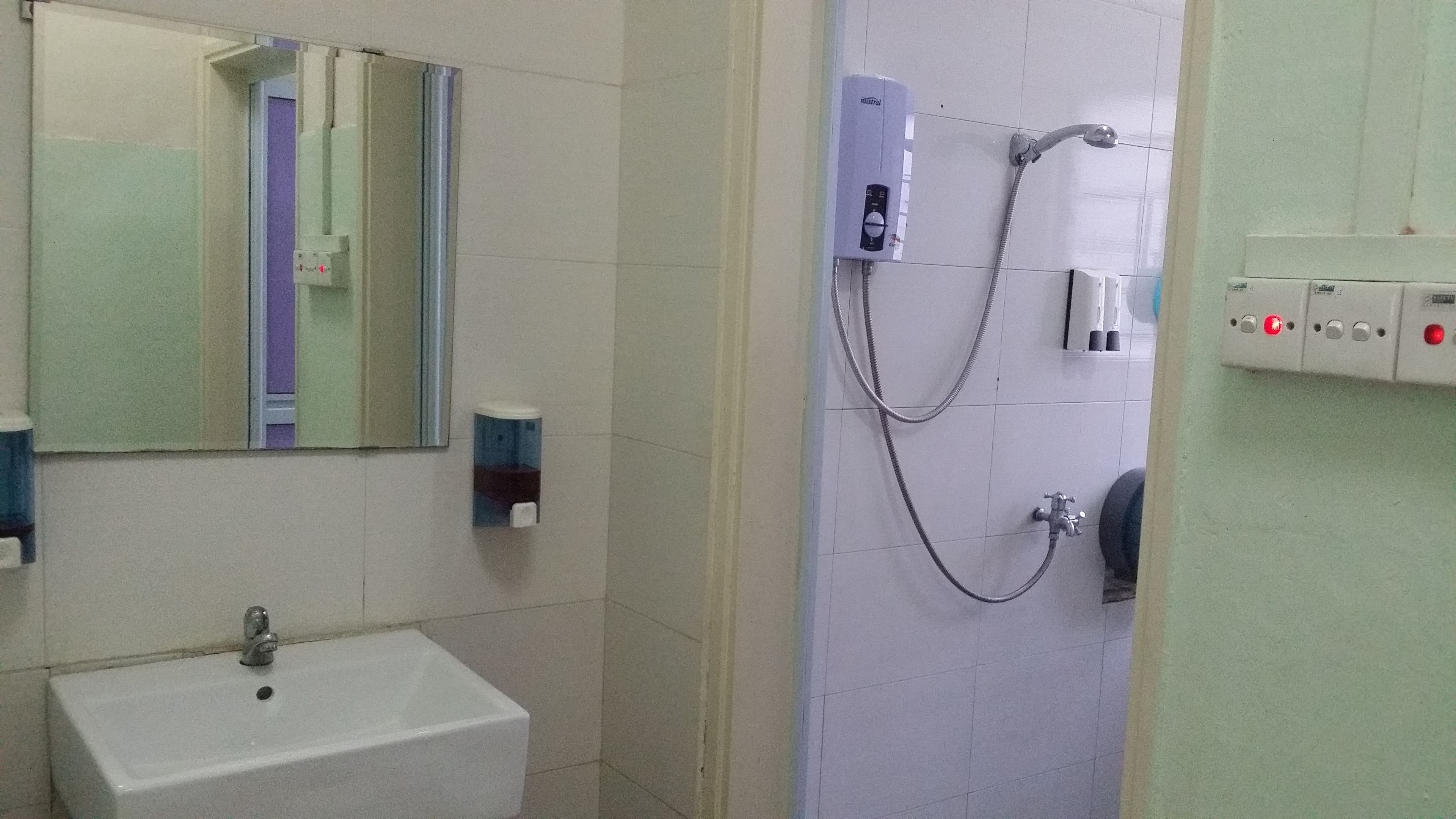 A bathroom with a sink, mirror, and shower.