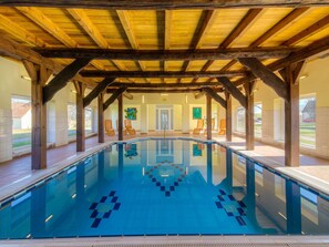 Una piscina techada, sillones reclinables de piscina