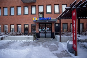 A building with a sign reading "CÅRDET" and a red banner with "INGÅNG STÅG GÅRDET" on the right.