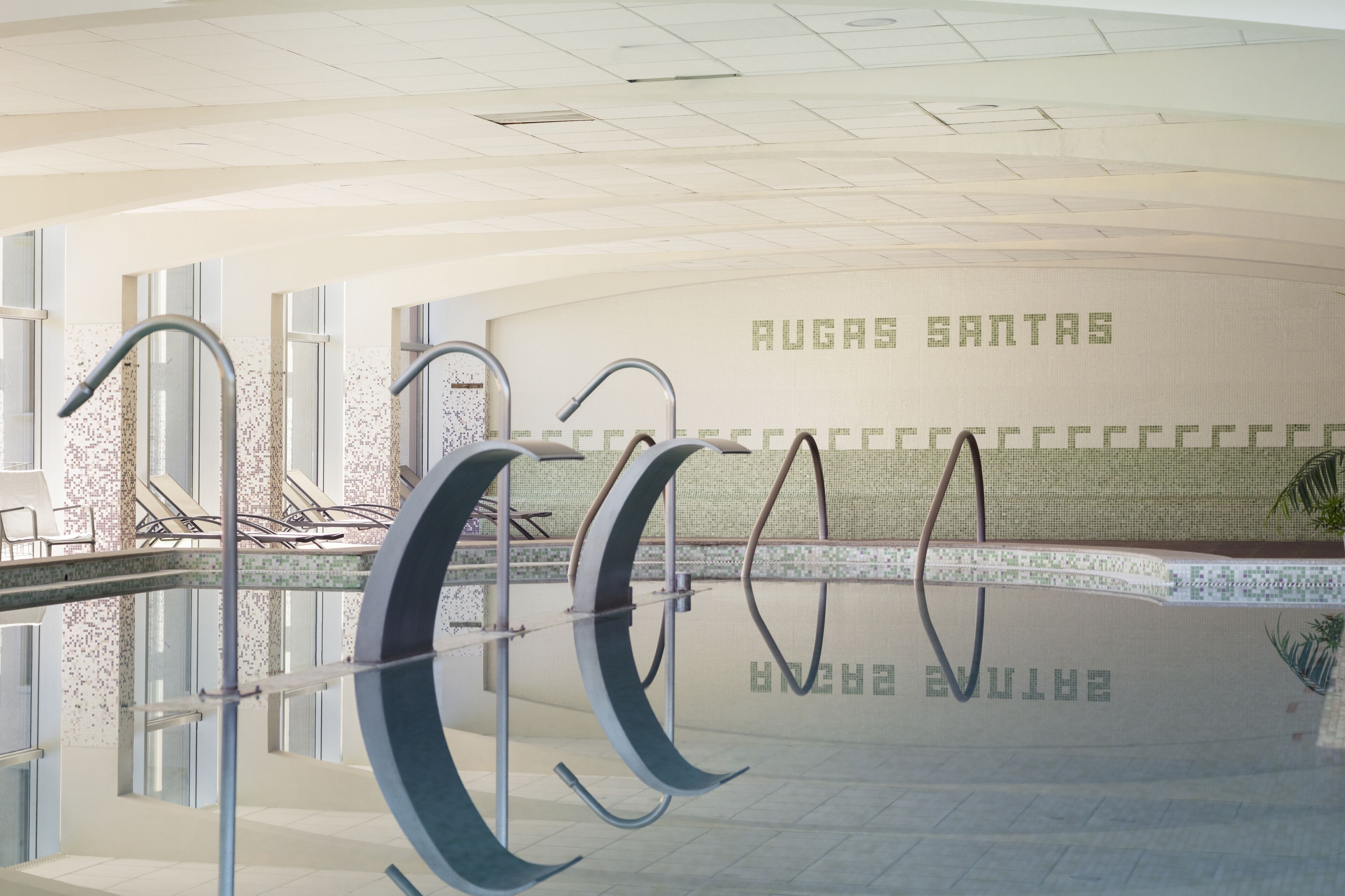 Una piscina con varios tableros de clavados y una pared con la inscripción 