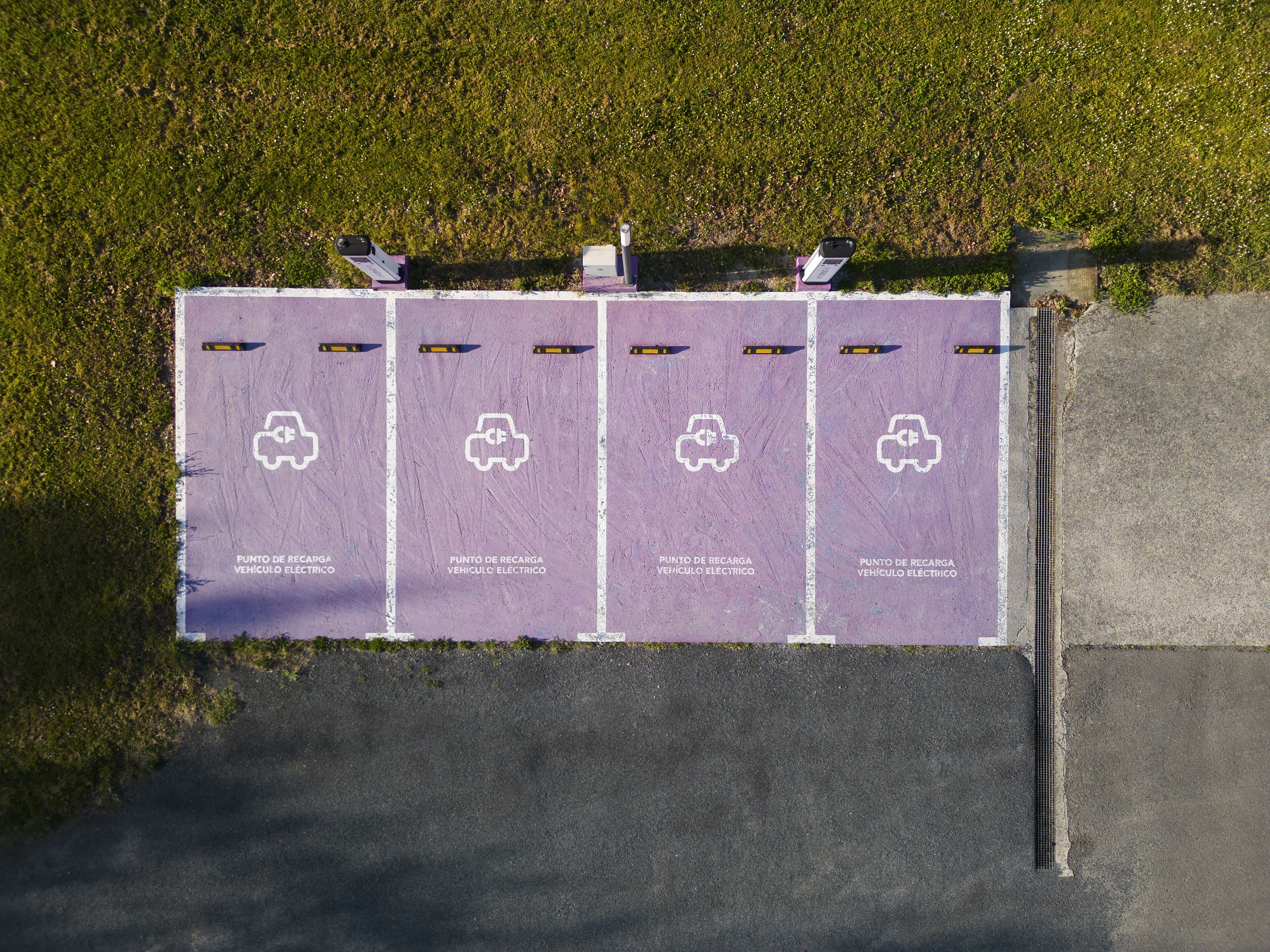 Un área de estacionamiento con estaciones de carga para vehículos eléctricos.