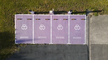 Un área de estacionamiento con estaciones de carga para vehículos eléctricos.