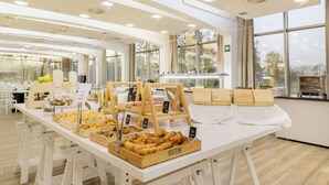 Montaje de bufé con diversos alimentos y bases de madera que muestran la etiqueta 'IBERIK'.