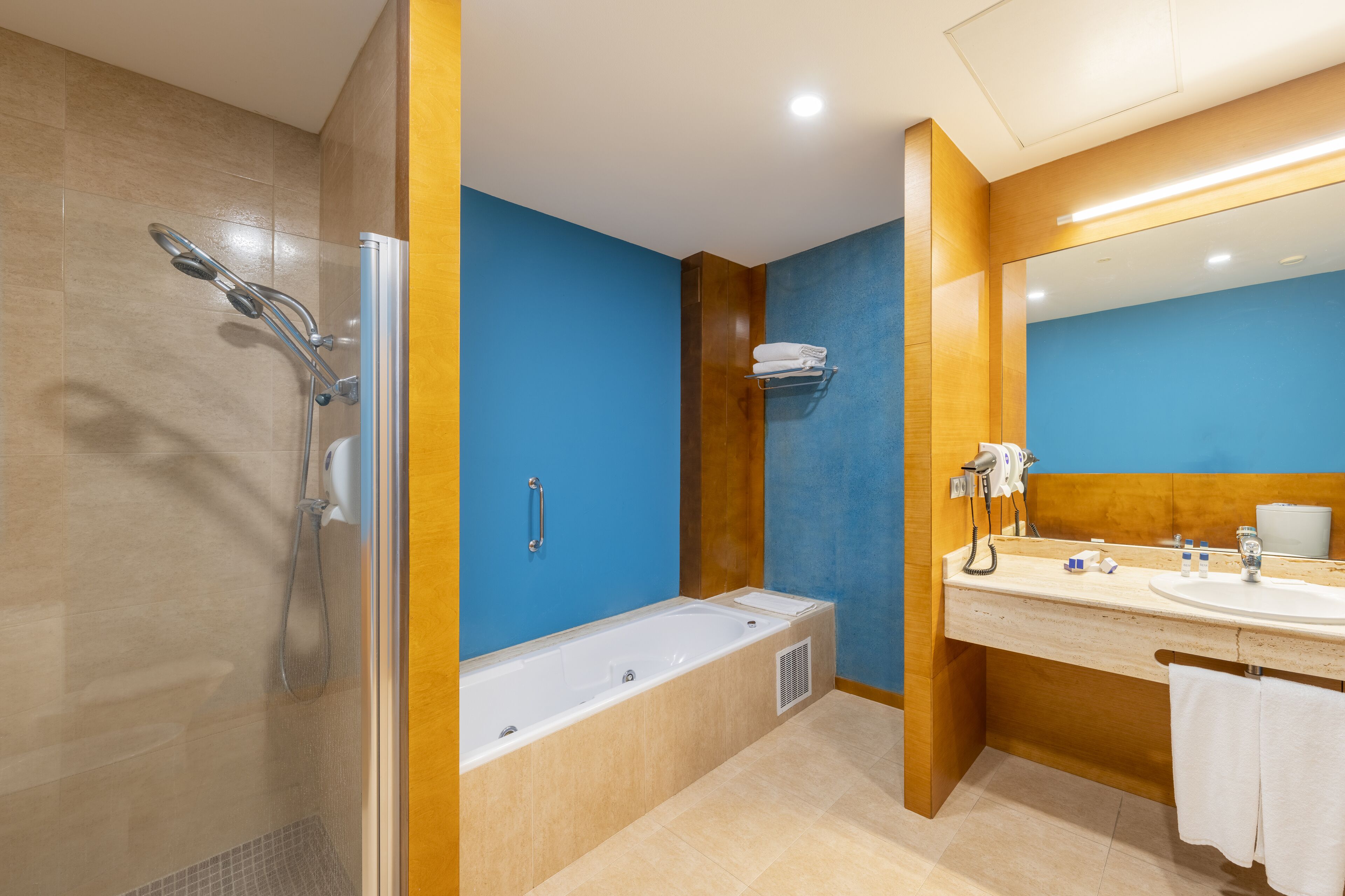 A modern bathroom with a bathtub, shower, and sink.