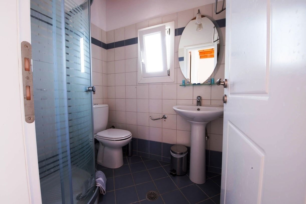 A small bathroom with a toilet, sink, and a window.