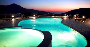 Una piscina al aire libre, sombrillas, tumbonas