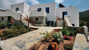 Un bâtiment moderne, de couleur blanche, avec un escalier en pierre menant à une porte.