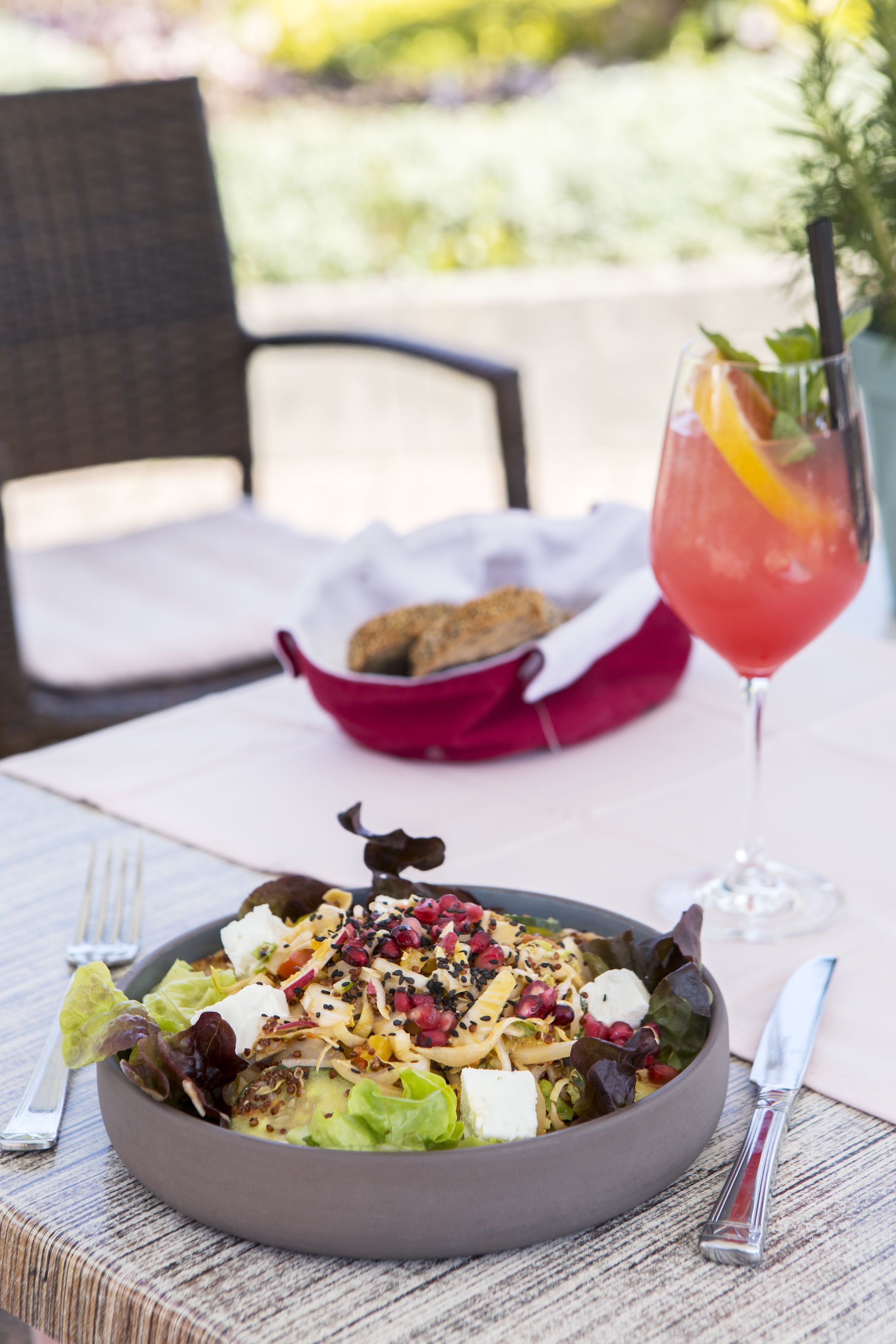 Un tazón de ensalada con una bebida sobre una mesa.