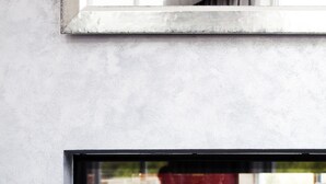 Une cheminée moderne avec une façade en verre, une table en verre devant, et un canapé sur la gauche.