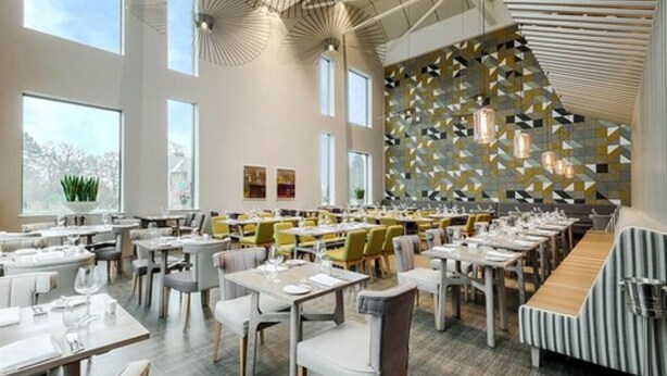 A modern restaurant with high ceilings, large windows, and a patterned wall. Tables are neatly arranged with chairs. - Peter Scott House, Birmingham (Birmingham)