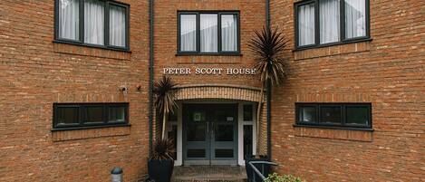 A brick building with a sign reading "Peter Scott House."