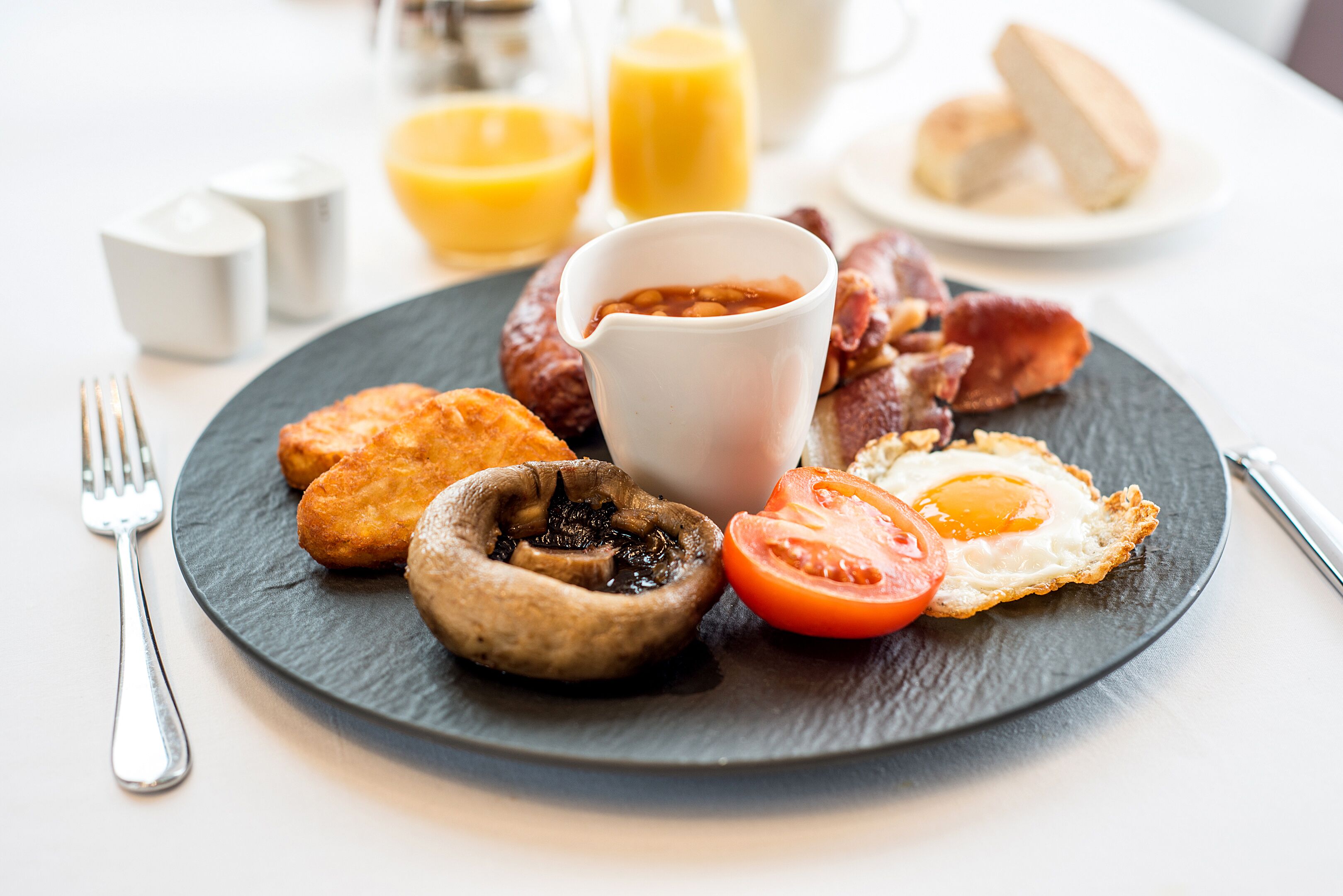 Ein Frühstücksteller mit Eiern, Speck, Pilzen und Bohnen.