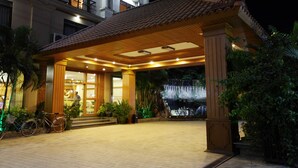 A hotel entrance with a covered walkway, potted plants, and a bicycle parked outside. - Ayarwaddy River View Hotel (Mandalay)