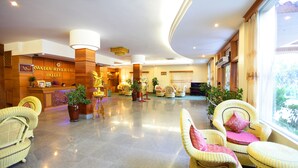 A spacious lobby with a reception desk, wicker furniture, and potted plants. - Ayarwaddy River View Hotel (Mandalay)