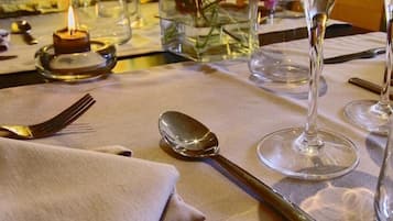 A table set for dining with wine glasses, cutlery, and a candle.