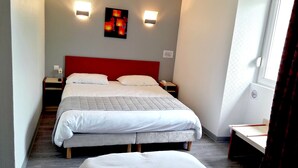 Een hotelkamer met een groot bed, twee nachtkastjes, een rood hoofdeinde en twee wandlampen.