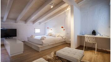 Un dormitorio moderno con cama, mesita de noche y escritorio con silla.